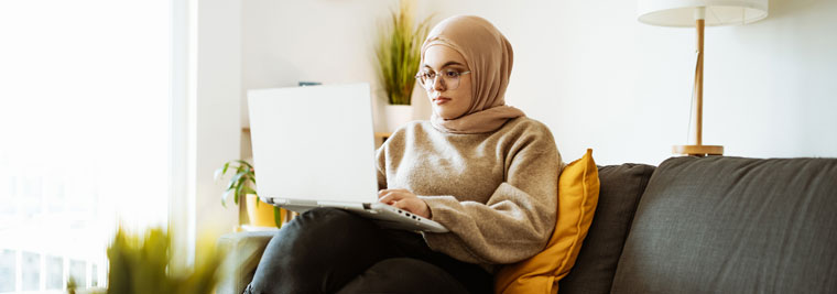 woman on her laptop on couch at home
