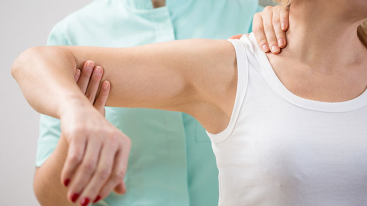 Image of a person whose arm is being examined by a healthcare professional
