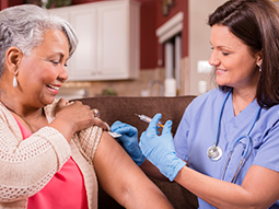 Immunologist giving injection to senior adult woman