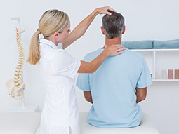 Spine care specialist examining patient’s back